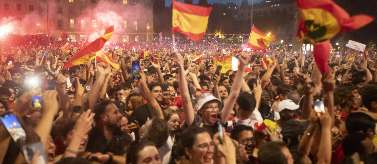 Banderas de España y botes de humo rojo en la Plaza de Cataluña, en Barcelona