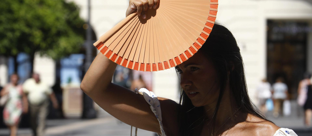 Una chica se protege con un abanico del sol en Córdoba