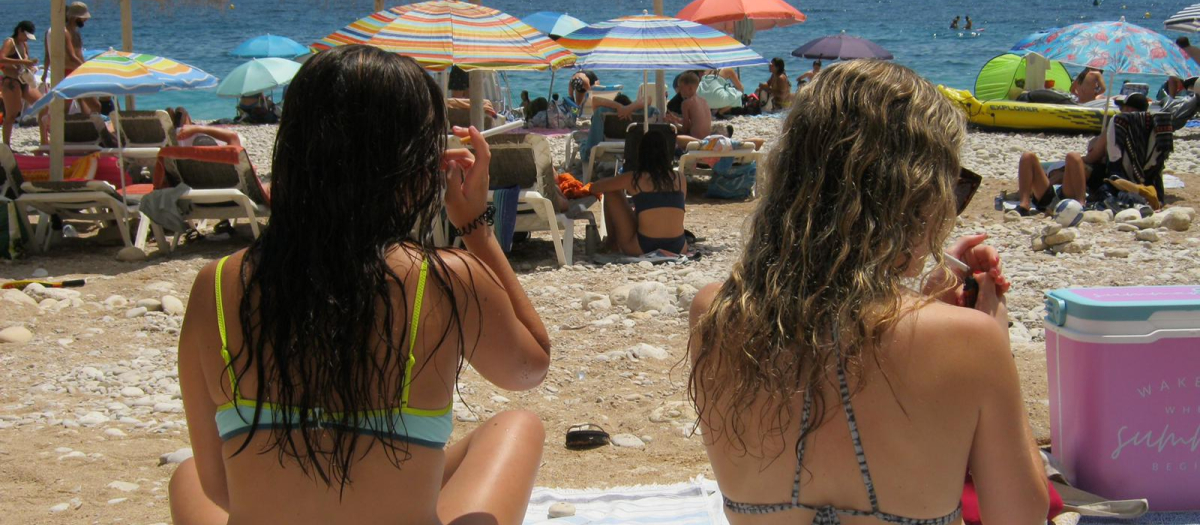 Dos chicas fuman en una playa de Benidorm, esta semana