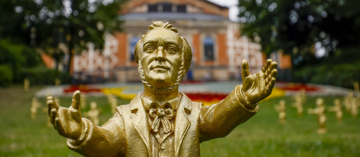 Una de las esculturas doradas de Wagner, obra del artista Ottmar Hoerl stand on the lawn in front of the 19th century Bayreuth Festival Opera House before the opening of the 112th Bayreuth Opera Festival (Festspiele), in Bayreuth, Germany, 25 July 2023. The Richard Wagner festival opens with the opera Parsifal and runs until 28 August. (Alemania) EFE/EPA/RONALD WITTEK