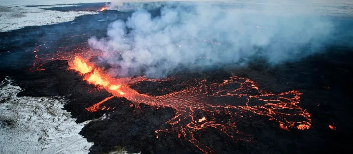 Fotografía aérea tomada con un dron muestra lava y humo saliendo de una fisura volcánica durante una erupción cerca de la ciudad de Grindavik