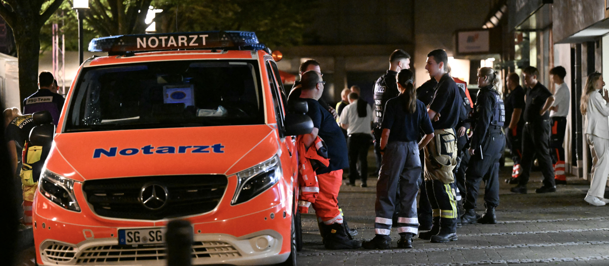 Una ambulancia y un policía cerca del festival donde ha tenido lugar el atentado en Solingen, Alemania