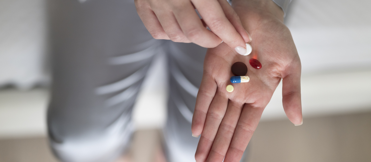 Enfermo en el hospital a punto de ingerir varias pastillas