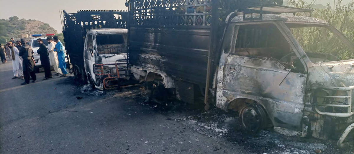 El personal de seguridad se encuentra cerca de los vehículos calcinados en el lugar del tiroteo en la carretera nacional en el distrito de Musakhail, provincia de Baluchistán