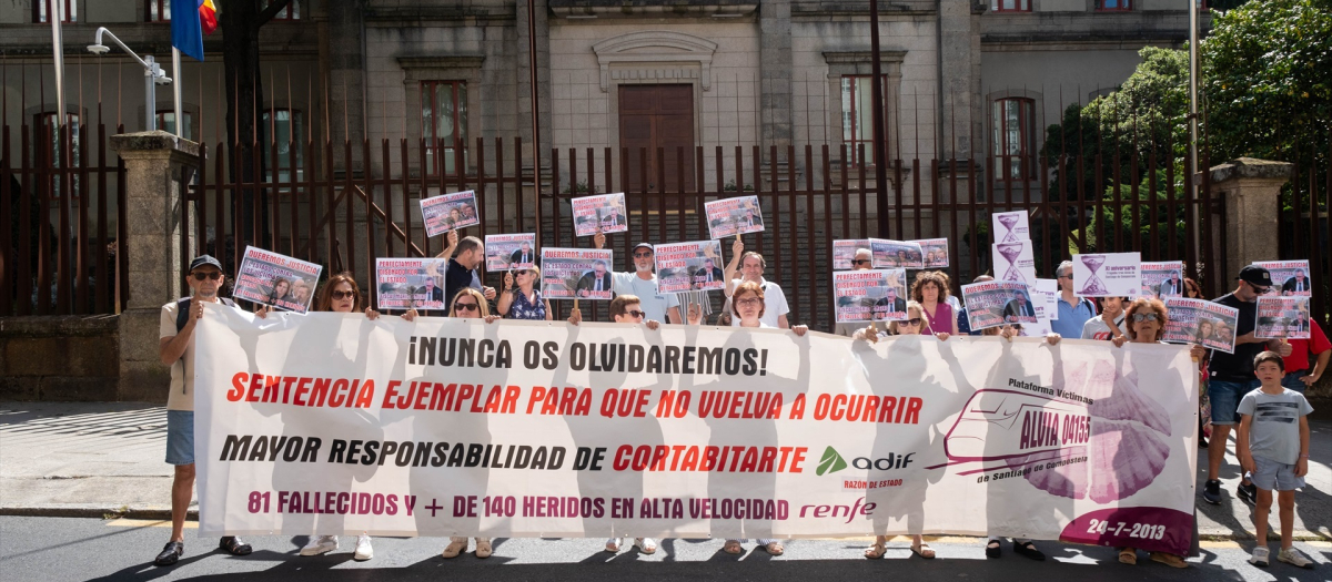 Varias personas con una pancarta y carteles durante una concentración de las víctimas de Angrois
24/7/2024