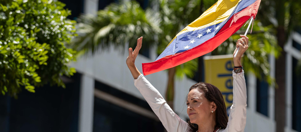 La líder opositora venezolana, María Corina Machado, agita una bandera ante seguidores este miércoles, en una manifestación en Caracas (Venezuela).