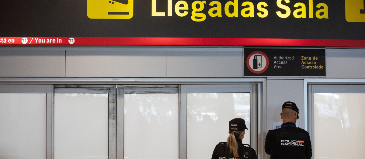 Dos agentes de la Policía Nacional en la puerta de llegadas de la terminal T1 del Aeropuerto Adolfo Suárez Madrid Barajas