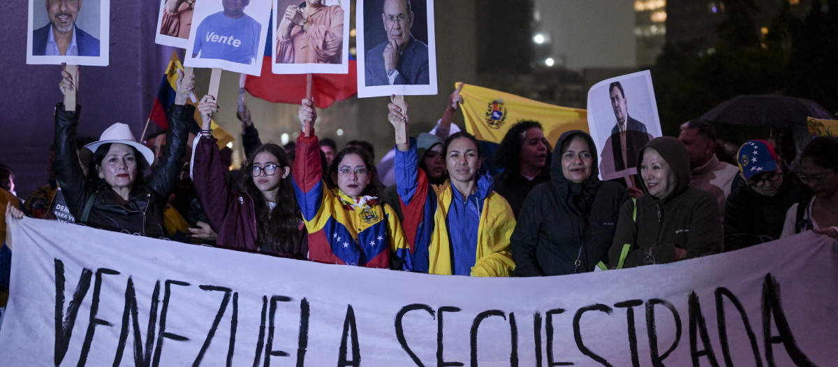 Venezolanos residentes en México sostienen una pancarta que dice "Venezuela secuestrada" durante una protesta contra el presidente venezolano Nicolás Maduro