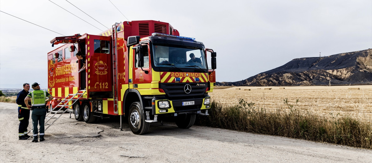 Un camión de los Bomberos trabaja en la zona quemada durante un incendio forestal