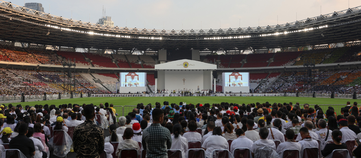 Catholic faithful listen as Pope Francis leads the holy mass at the Gelora Bung Karno Stadium in Jakarta on September 5, 2024. (Photo by Ajeng Dinar Ulfiana / POOL / AFP)