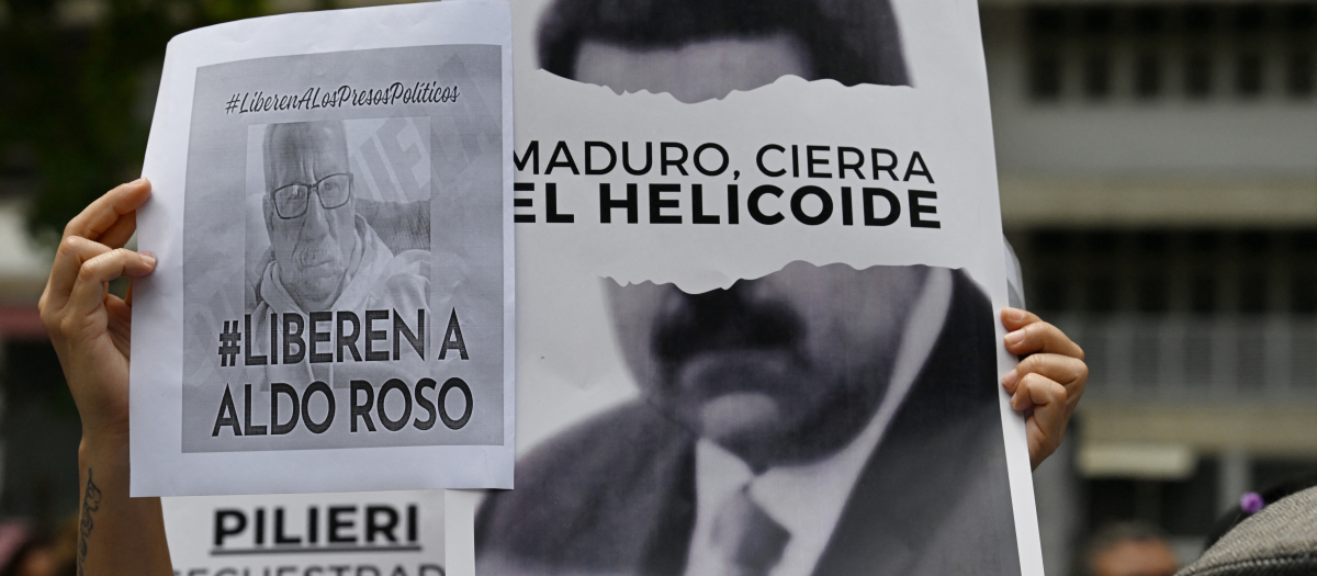 Manifestantes sostienen carteles contra el Gobierno de Nicolás Maduro y para exigir la libertad de los presos políticos durante una protesta en la embajada de Brasil en Caracas