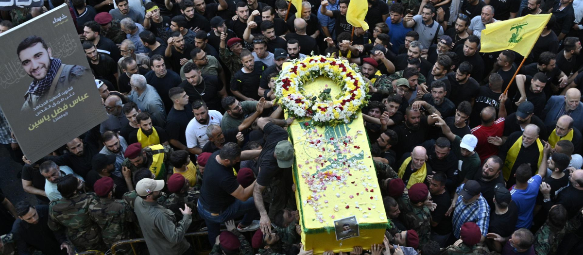 Los dolientes llevan el ataúd de una de las personas que murieron un día antes en las explosiones de buscapersonas, durante la procesión fúnebre en el suburbio sur de Beirut, Líbano