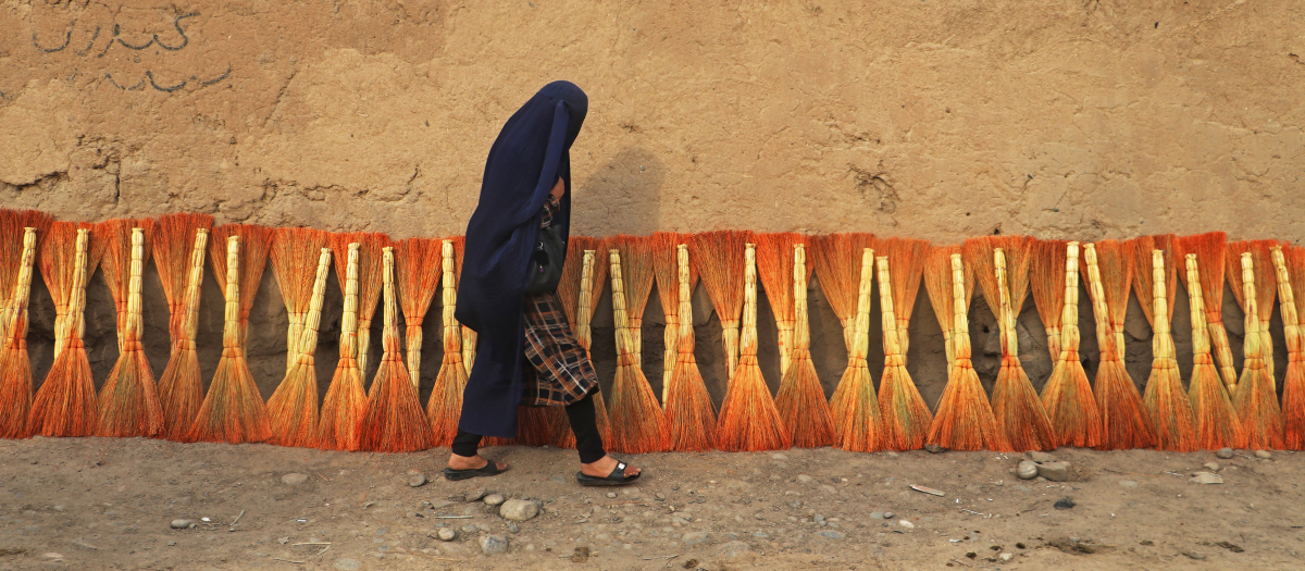 Una mujer afgana vestida con burka camina por una calle en el distrito de Fayzābād, provincia de Badajshán