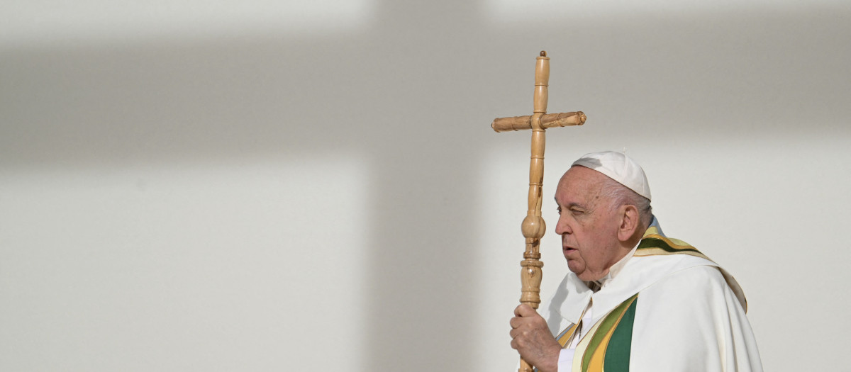 Pope Francis holds a cross during at holy mass a King Baudouin stadium, in Brussels on September 29, 2024. The pope is on a four-day apostolic journey to Luxembourg and Belgium. (Photo by Alberto PIZZOLI / AFP)