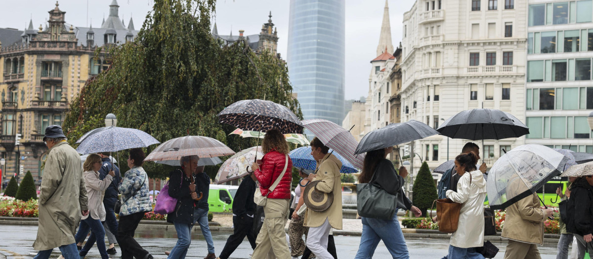 Personas se protegen con paraguas de la lluvia en Bilbao