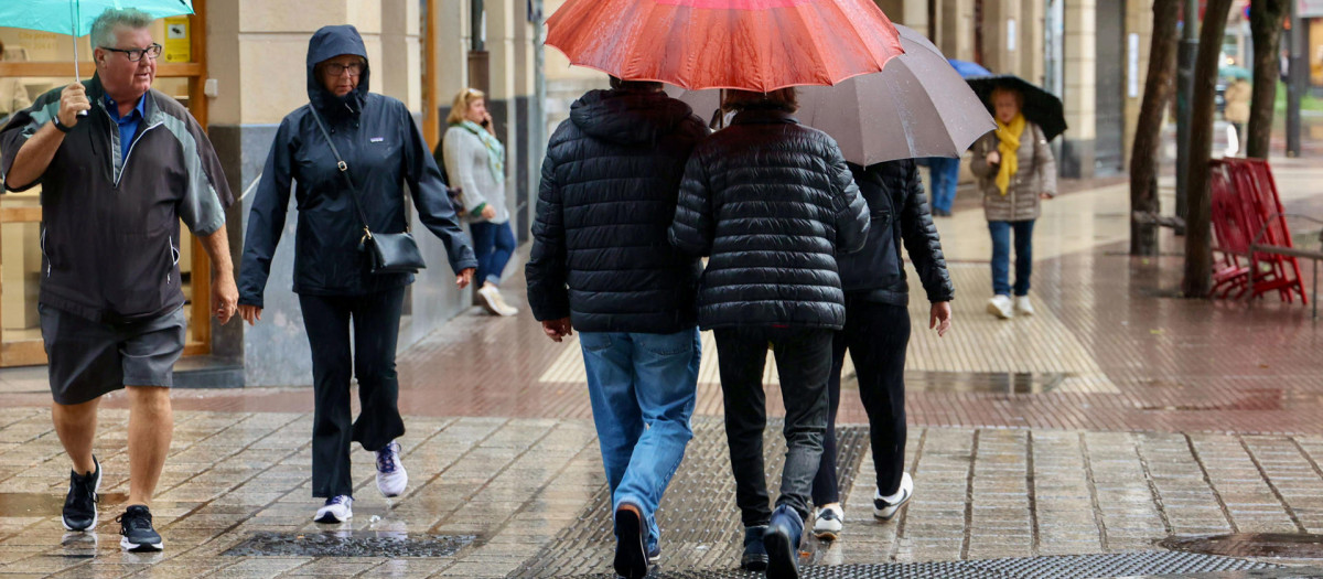 Varias personas se protegen de la lluvia en Logroño