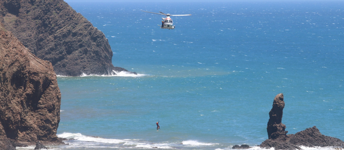 Salvamento Marítimo baja con una cuerda del helicóptero para trasladar el cuerpo sin vida del inmigrante