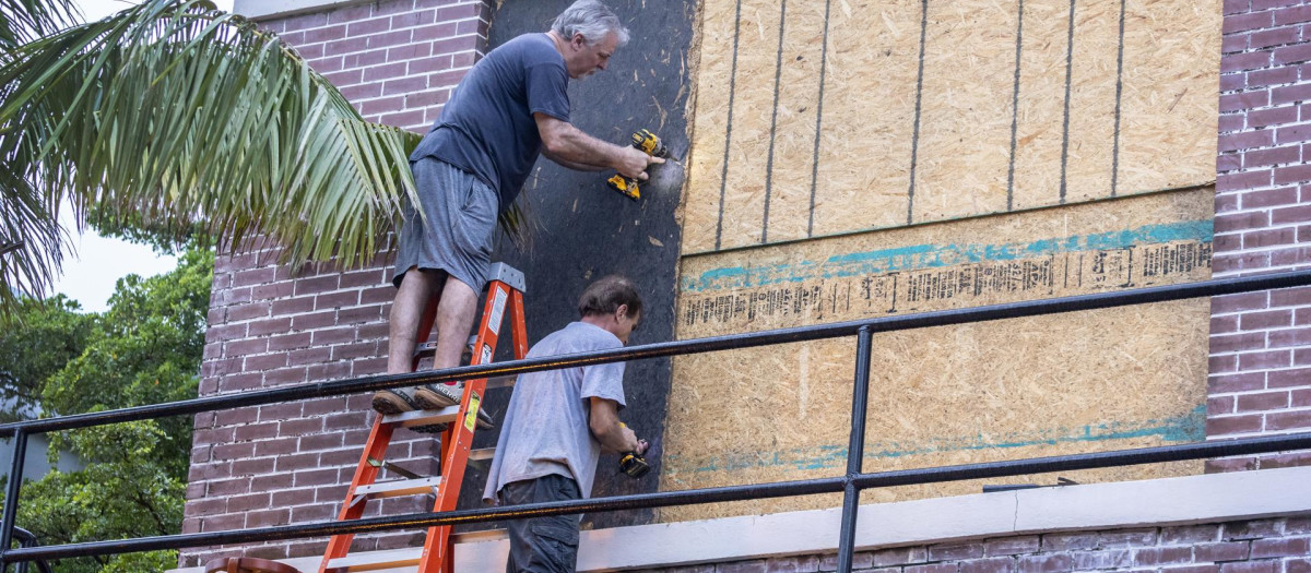 Los residentes de Fort Myers colocan madera contrachapada sobre las ventanas