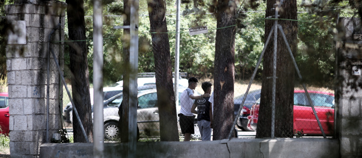 Dos menas caminan por las inmediaciones del centro de acogida de la Casa de Campo