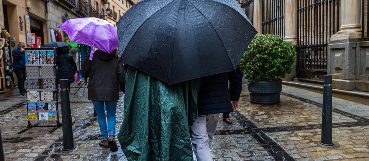 Varias personas se protegen de la lluvia este sábado en Toledo