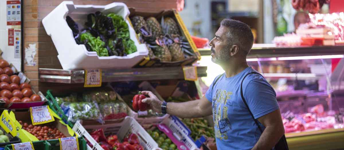 Un hombre comprando en un mercado de abastos de Triana (Sevilla)