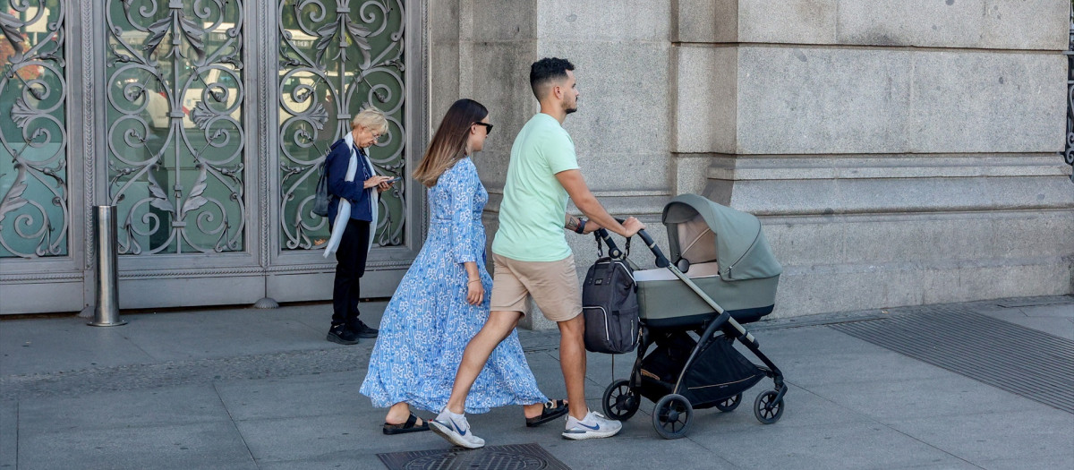 Dos personas pasean con un carrito de bebé