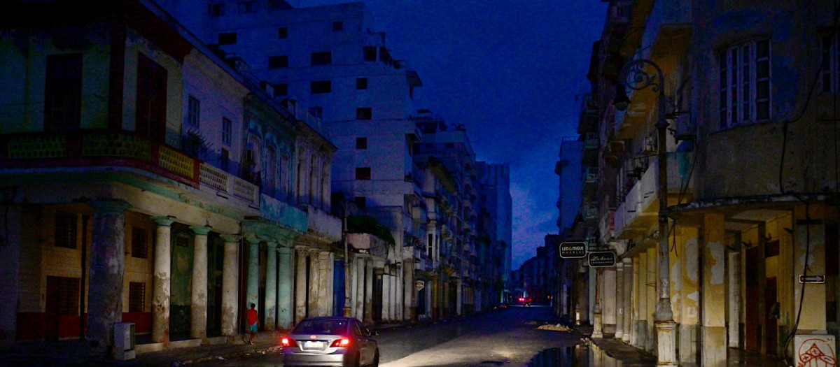 Un coche circula por una calle durante el apagón total que sufre Cuba