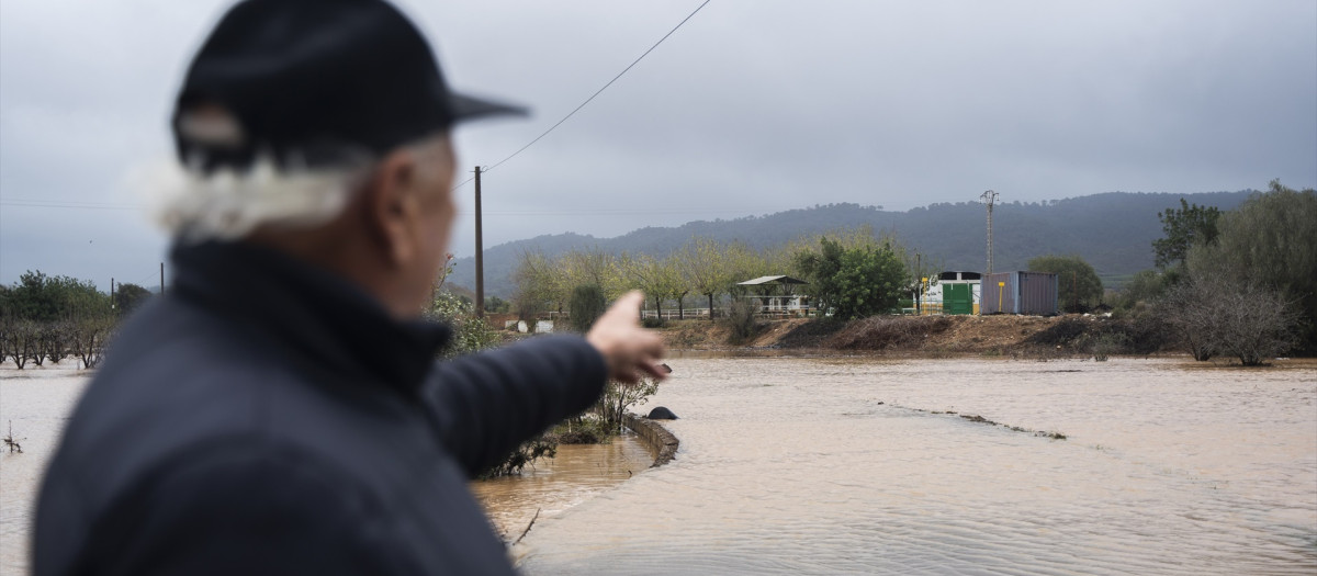 Un vecino observa la crecida del Rio Magre