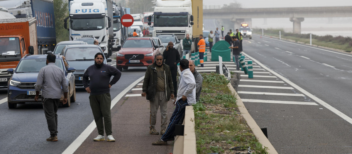 Varios conductores tirados en la carretera, anegada por la DANA, en Valencia, este jueves