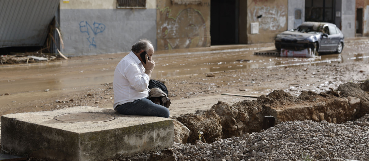 Un hombre habla por teléfono en una de las zonas de Valencia afectadas