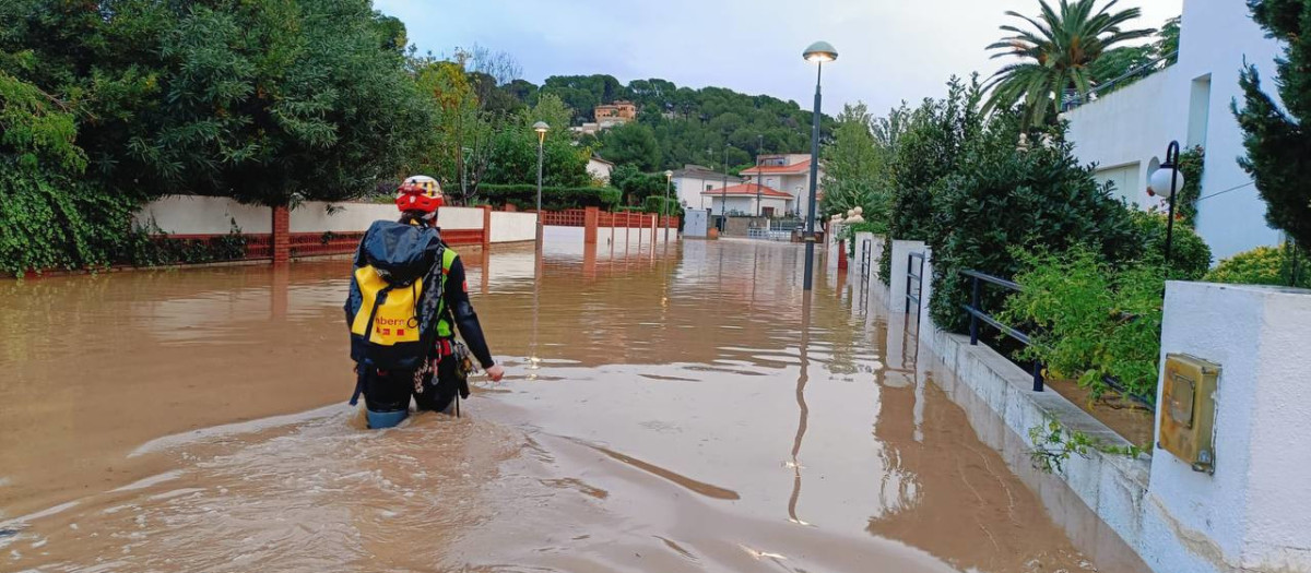 Un bombero camina por una calle inundada en la Móra, en Tarragona