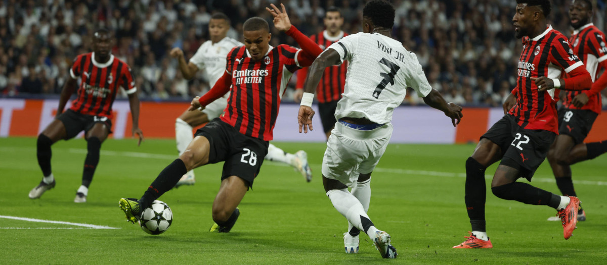 El defensa alemán del Milan, Malick Thiaw (i), se interpone ante el delantero brasileño del Real Madrid, Vinicius Junior, durante el encuentro correspondiente a la fase regular de la Liga de Campeones que disputan hoy martes Real Madrid y Milan en el estadio Santiago Bernabéu, en Madrid. EFE / Juanjo Martín.