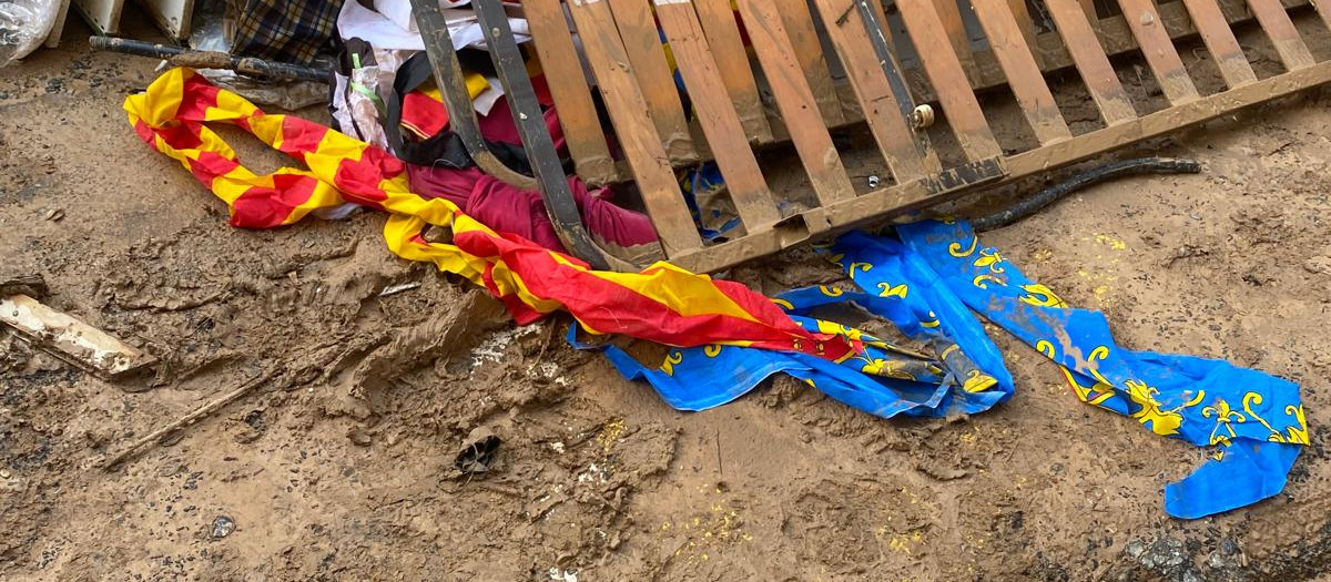 Una bandera de la Comunidad Valenciana, entre el barro y un somier tras la DANA