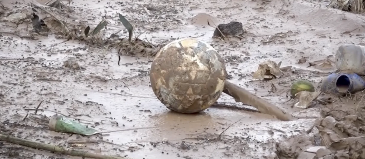 Un balón de fútbol lleno de barro por culpa de la DANA