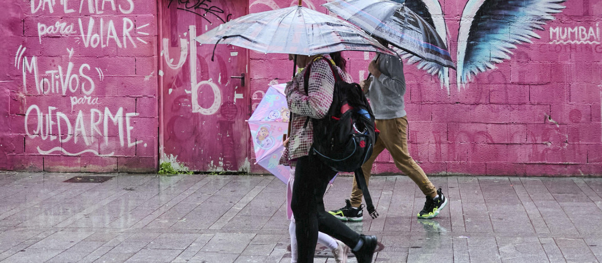 Varias personas caminan protegidas para la lluvia por Gandía (Valencia)