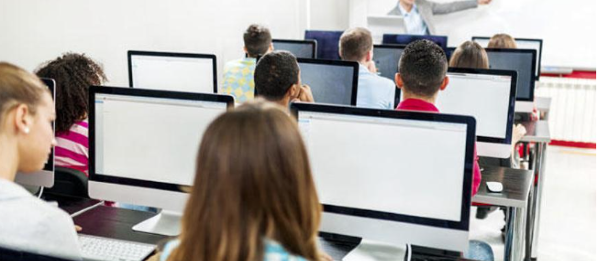 Varios alumnos usan ordenadores en una clase, en una imagen de archivo