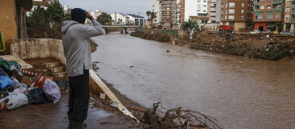 Un hombre observa el caudal del Barranco el Poyo