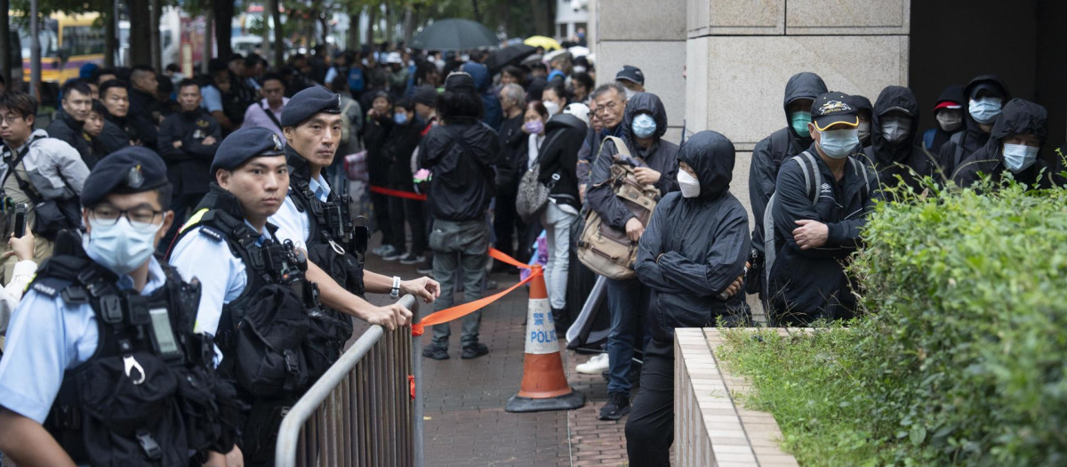 Ciudadanos haciendo cola dispuestos a entrar a los juzgados para presenciar el mayor juicio de seguridad nacional de Hong Kong