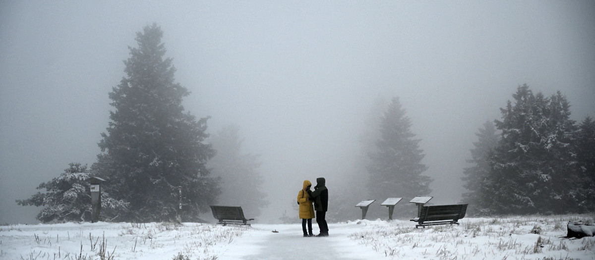 Una pareja camina entre árboles cubiertos de nieve en la montaña Kahler Asten, en el oeste de Alemania