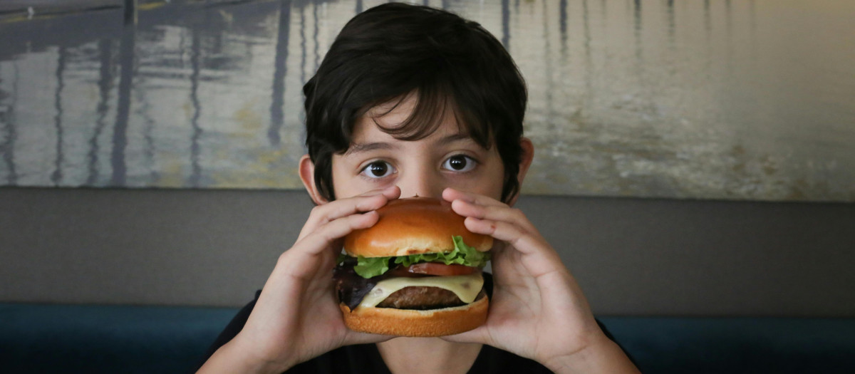 Un niño comiendo una hamburguesa