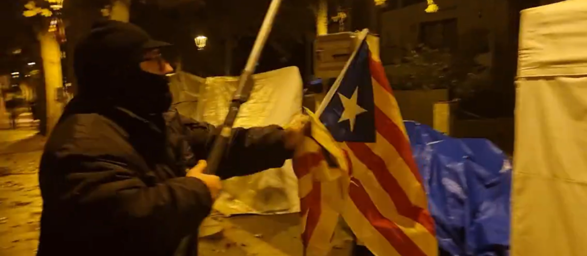 Uno de los miembros de las brigadas retirando una estelada