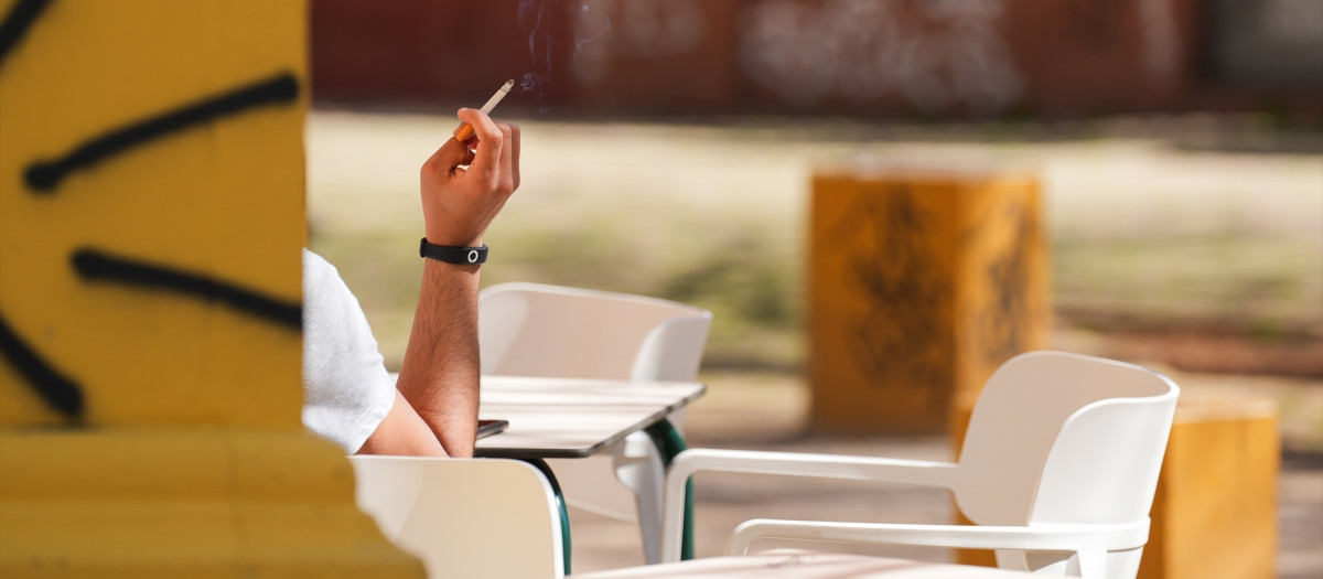 Una persona fumando en una terraza