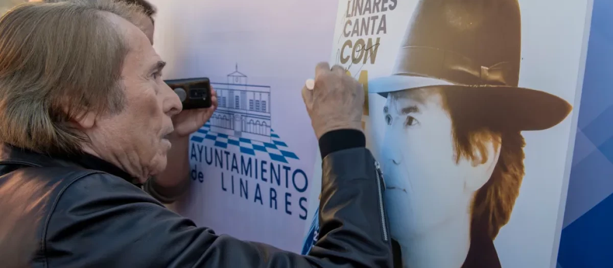 El cantante Raphael firmando una dedicatoria antes de grabar el villancico ‘El Tamborilero’ en Linares