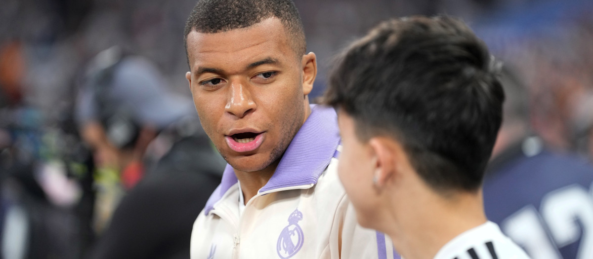 Kylian Mbappe habla con el niño con el que salió de la mano al encuentro frente al Getafe disputado el pasado domingo en el Bernabéu