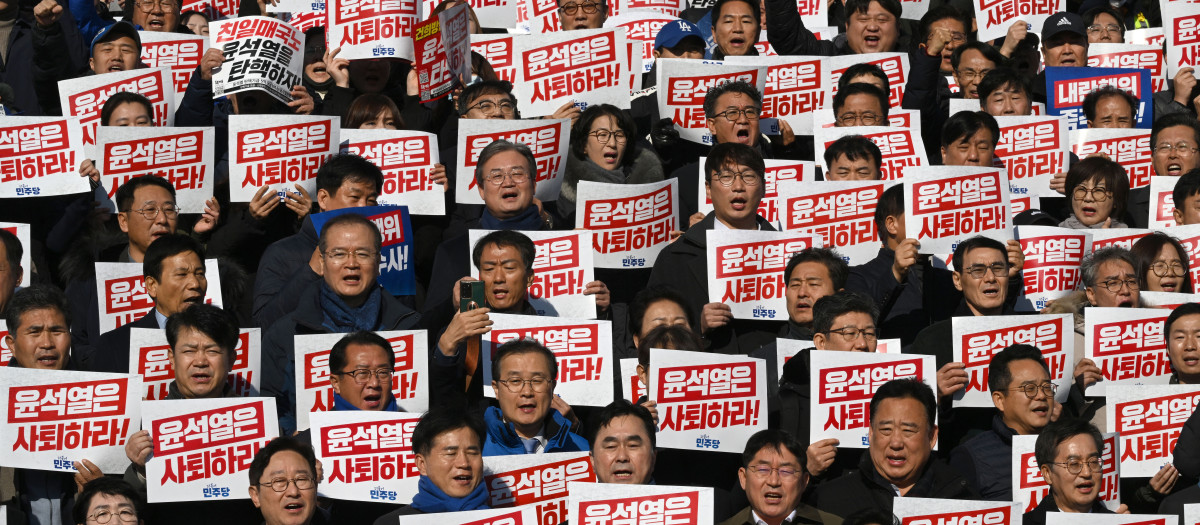 Legisladores y miembros del principal partido de oposición de Corea del Sur, el Partido Democrático, sostienen carteles en los que se puede leer "¡Yoon Suk Yeol debería dimitir!"