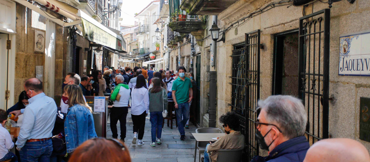 Varias personas en una calle de terrazas de Baiona, en Vigo