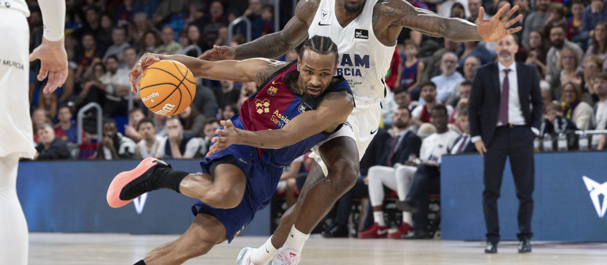 El jugador del FC Barcelona Punter en acción ante el jugador del UCAM Universidad Ennis este domingo, durante el partido de la Liga Endesa, entre el Barcelona y el UCAM Universidad, en el Palau Blaugrana de Barcelona