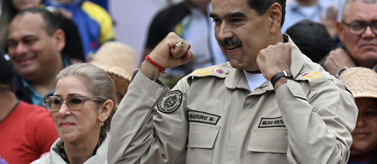 Venezuela's President Nicolas Maduro gestures next to First Lady Cilia Flores during an event marking the 165th anniversary of the Battle of Santa Ines in Caracas on December 10, 2024. (Photo by Juan BARRETO / AFP)