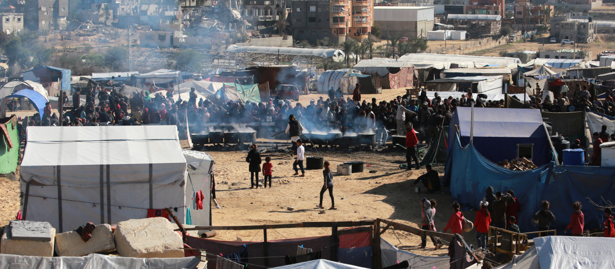 Un grupo de palestinos esperan una ración de comida en Khan Yunis, en el sur de la franja de Gaza