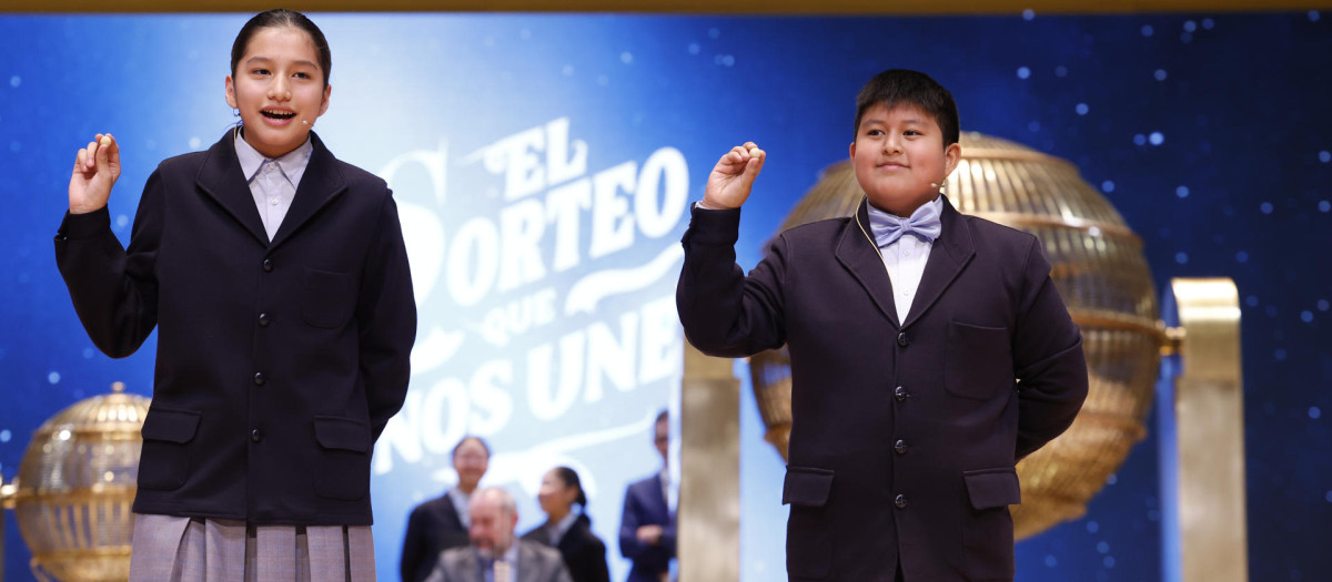 Los niños de la Residencia San Ildefonso de Madrid Piero Rai Chávez (d) y Alisce Ríos (i), muestran el número 72.480, el Gordo de Navidad, dotado con 4.000.000 euros a la serie